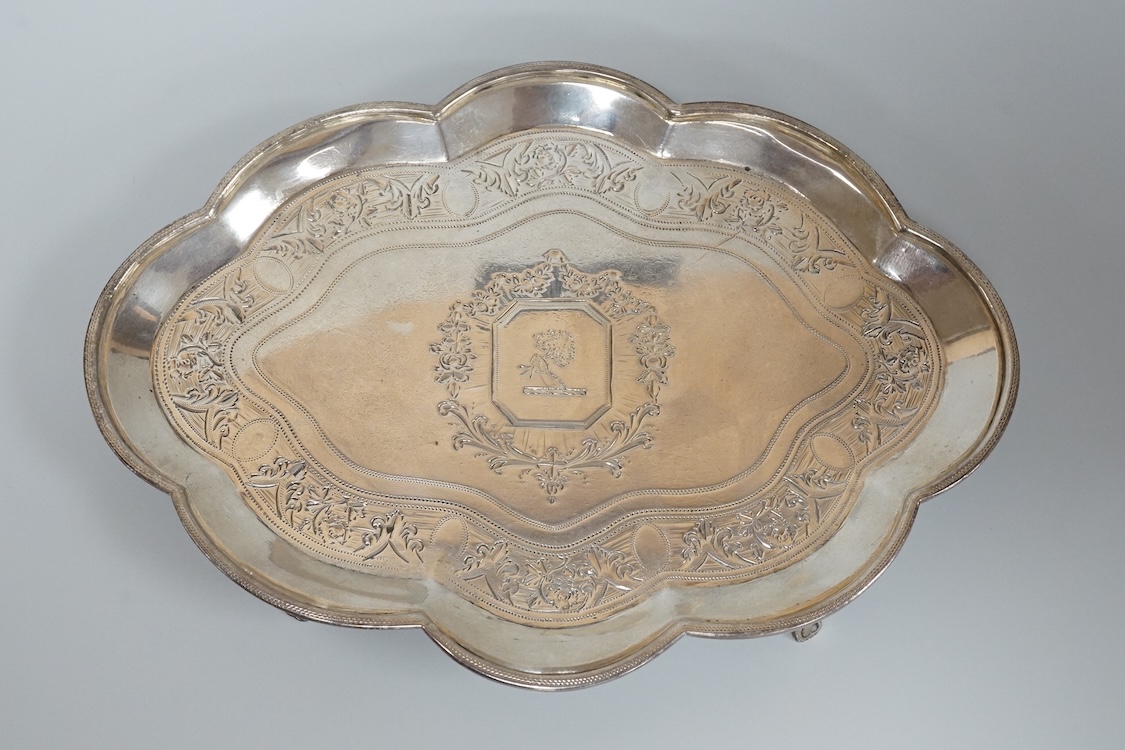 A George III silver cusped oval teapot stand, by Charles Aldridge, London, 1792, with engraved crest and foliate band, on four cabriole feet, London, 1792, 18.8cm, 5oz.